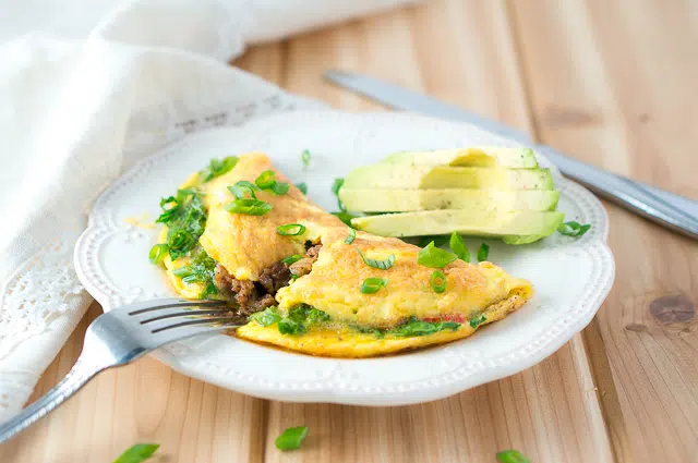 Delicious Kale and Sausage Omelet ready to be served, garnished with fresh green onions.