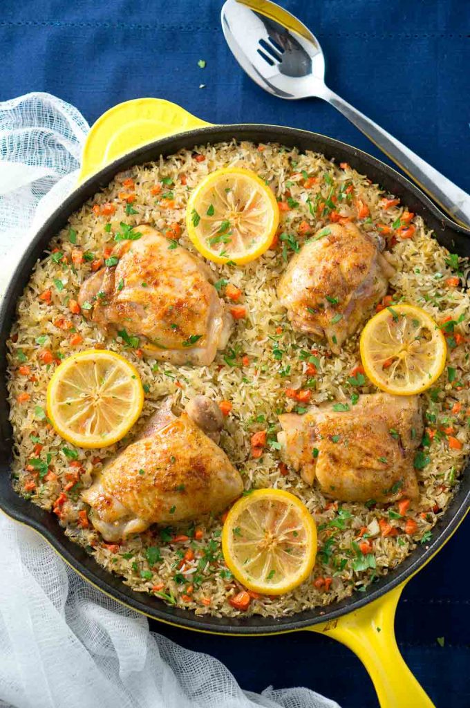 One Skillet Mediterranean Chicken and Rice is an easy and delicious meal the whole family will love. Garlic-seasoned chicken thighs on a bed of rice mixed with colorful veggies.