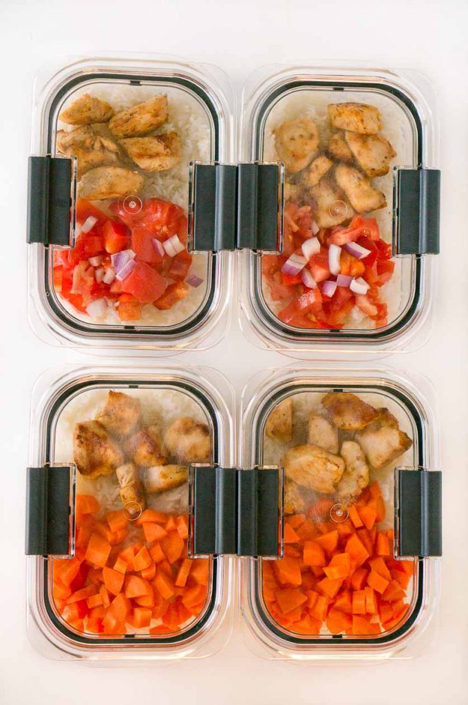 A plastic container filled with meat rice and vegetables