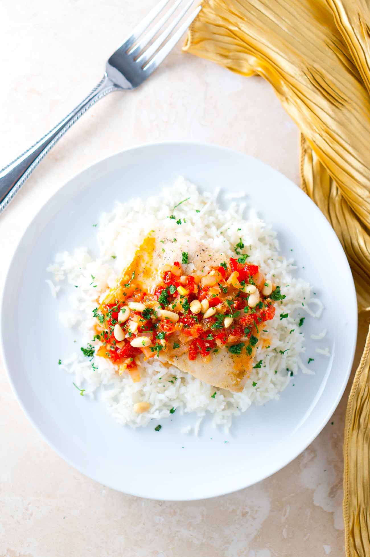 Fish served with a sauce on a bed of rice