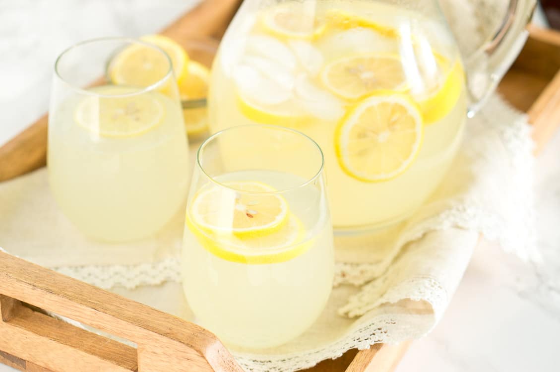 homemade lemonade recipe served in glasses on a wooden tray