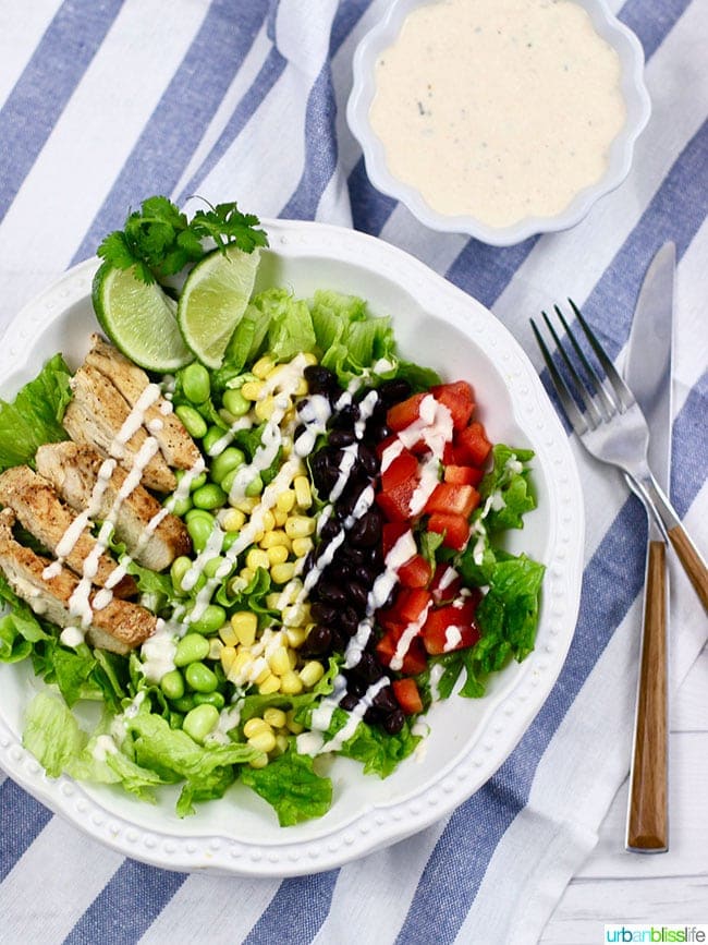 BBQ Chicken Salad with dressing on a plate with fork and knife