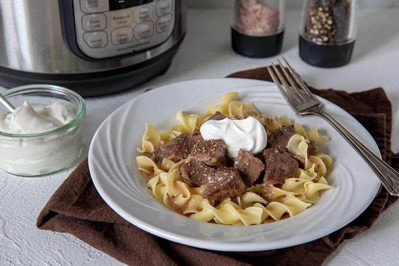 Instant Pot beef sirloin tips in gravy on plate of egg noodles