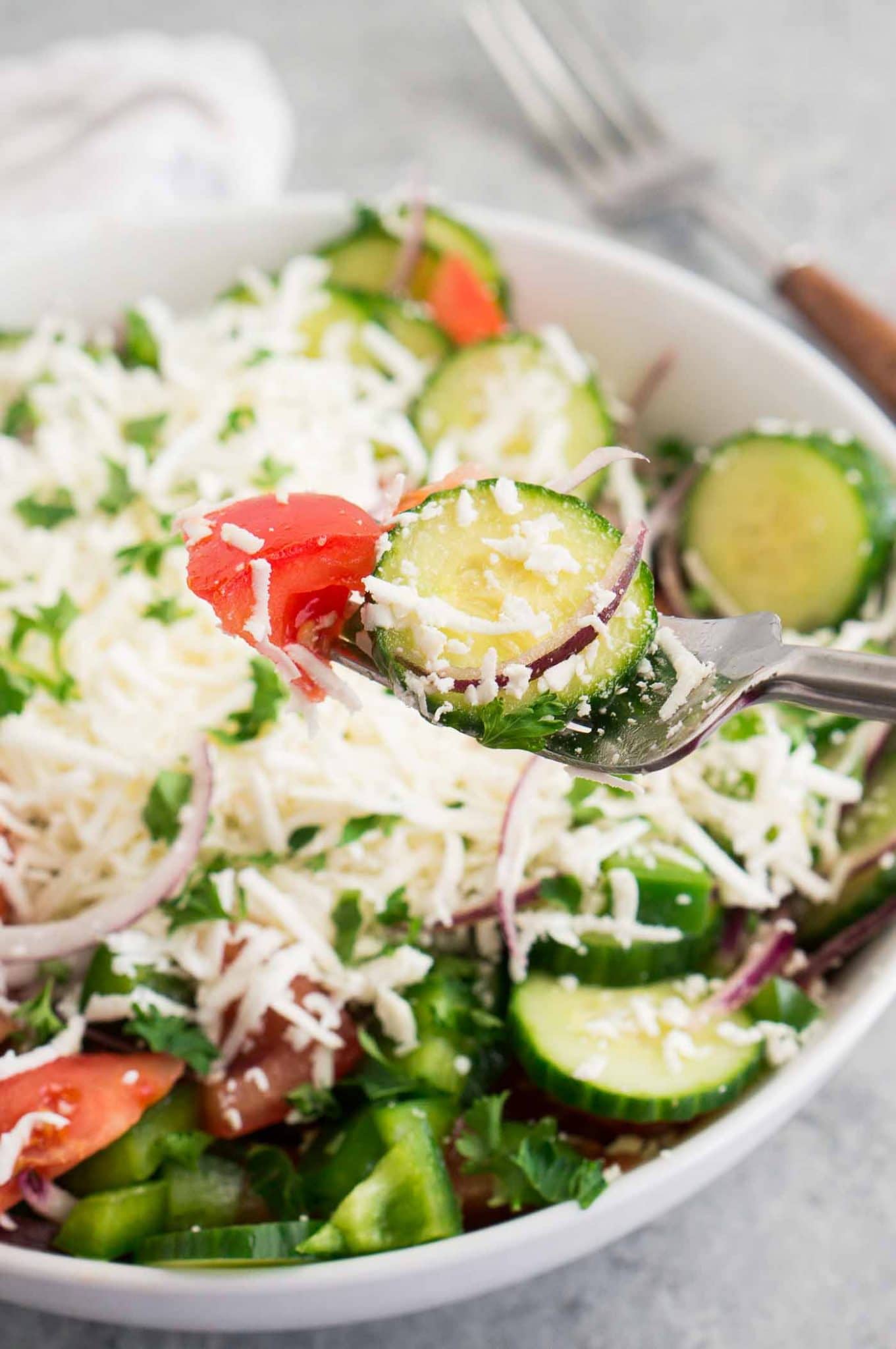 cucumber tomato and grated feta salad in a bowl