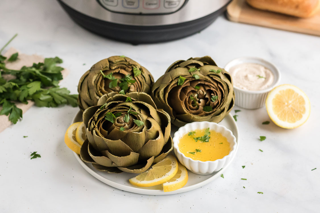 artichokes in the instant pot served with a dip