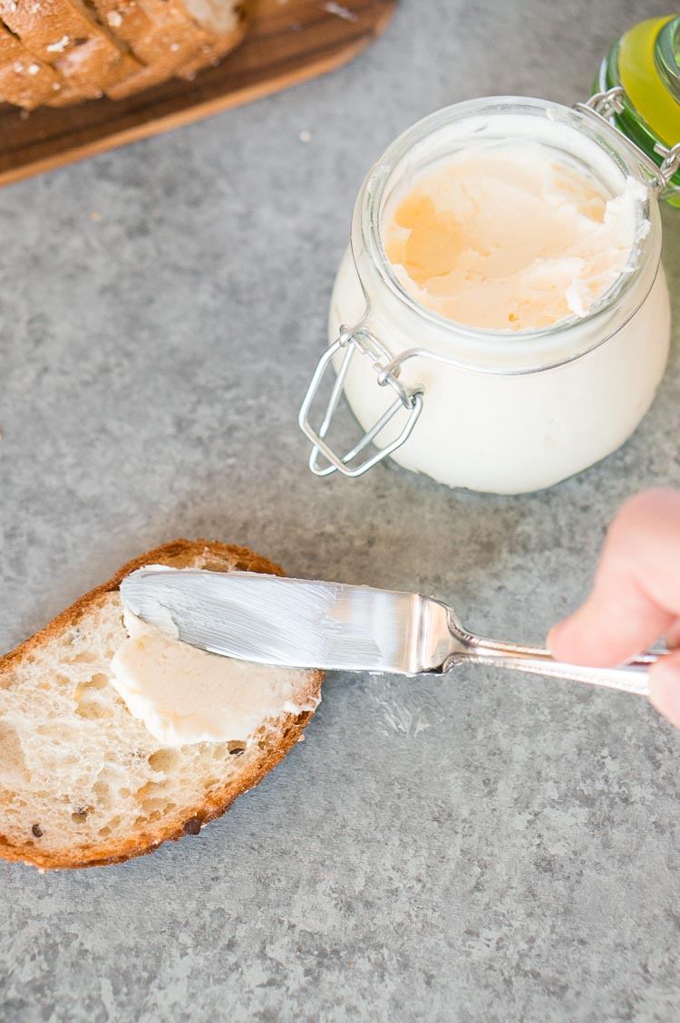 spreading homemade butter on a slice of bread