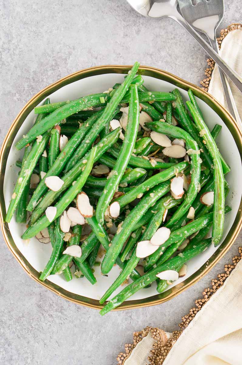 green beans with slivered almonds and garlic in a white bowl