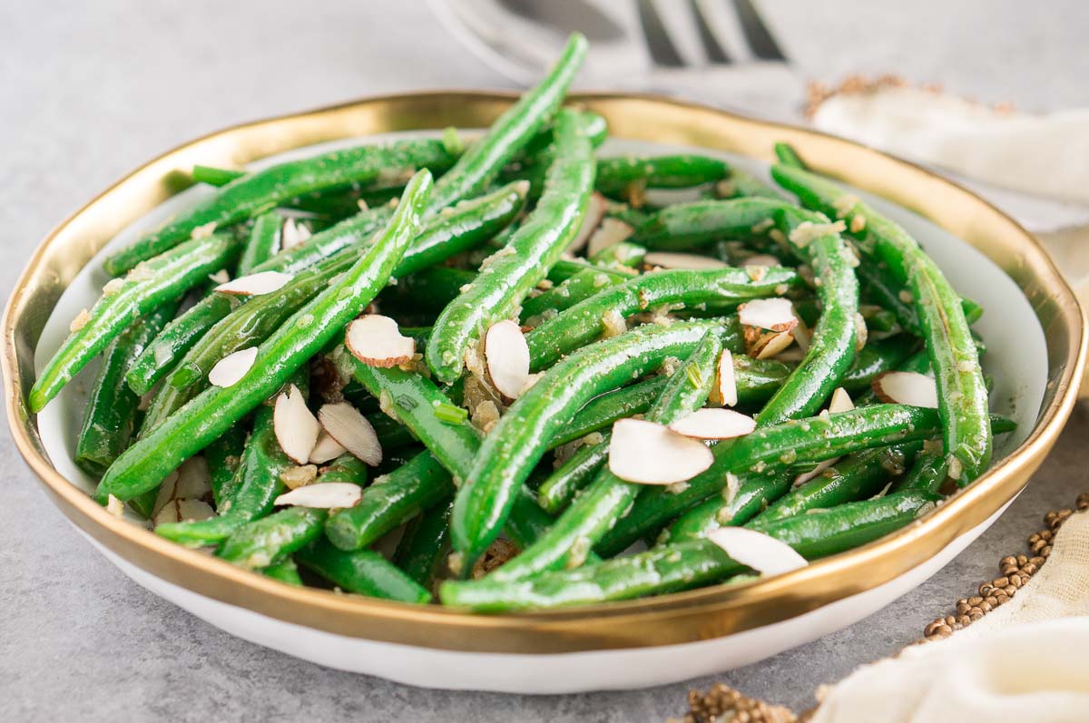 green beans with almonds in a white bowl