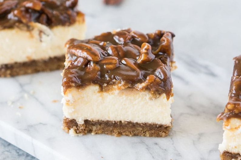 pecan pie cheesecake bars on a marble board