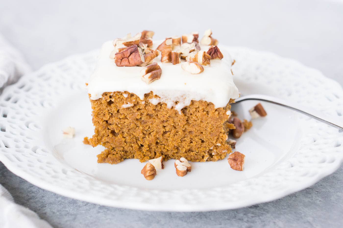 close up image of pumpkin cake with cream cheese frosting