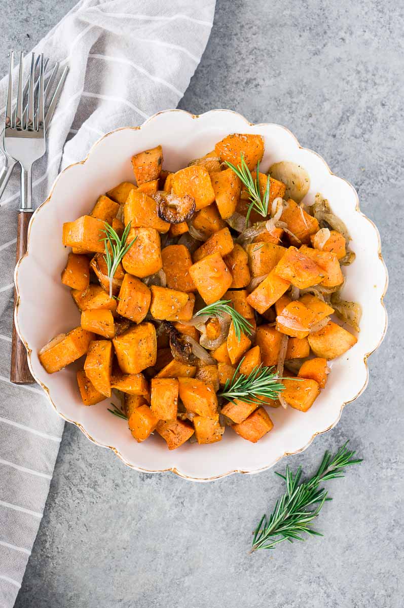sweet potatoes and onions with rosemary in a bowl