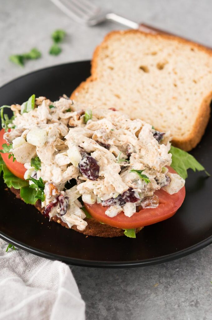 old fashioned turkey salad sandwich on a black plate