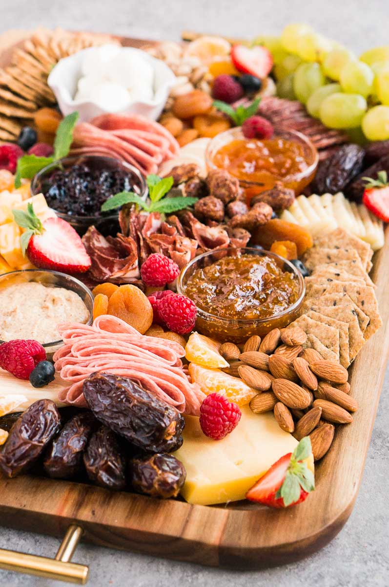 close up of snack board with crackers, fruit and cheese