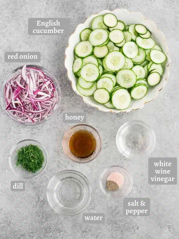 cucumbers red onion and dressing ingredients on a board