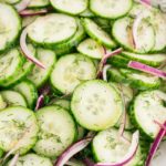 cucumber slices and dressing in a white bowl
