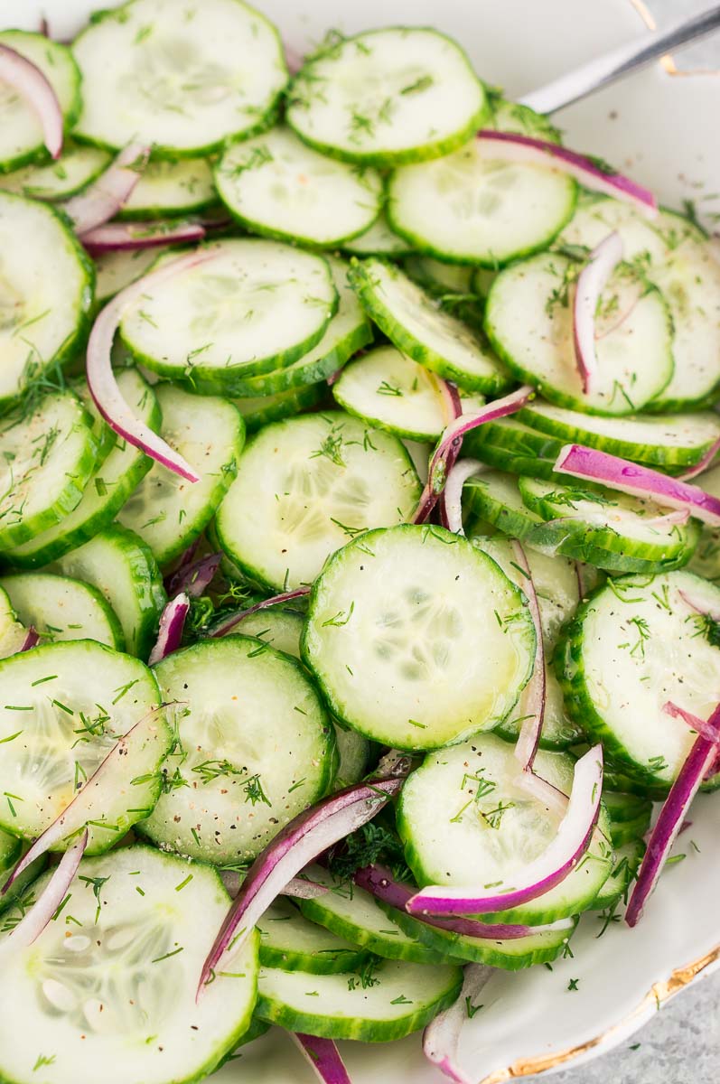 cucumber slices and dressing in a white bowl