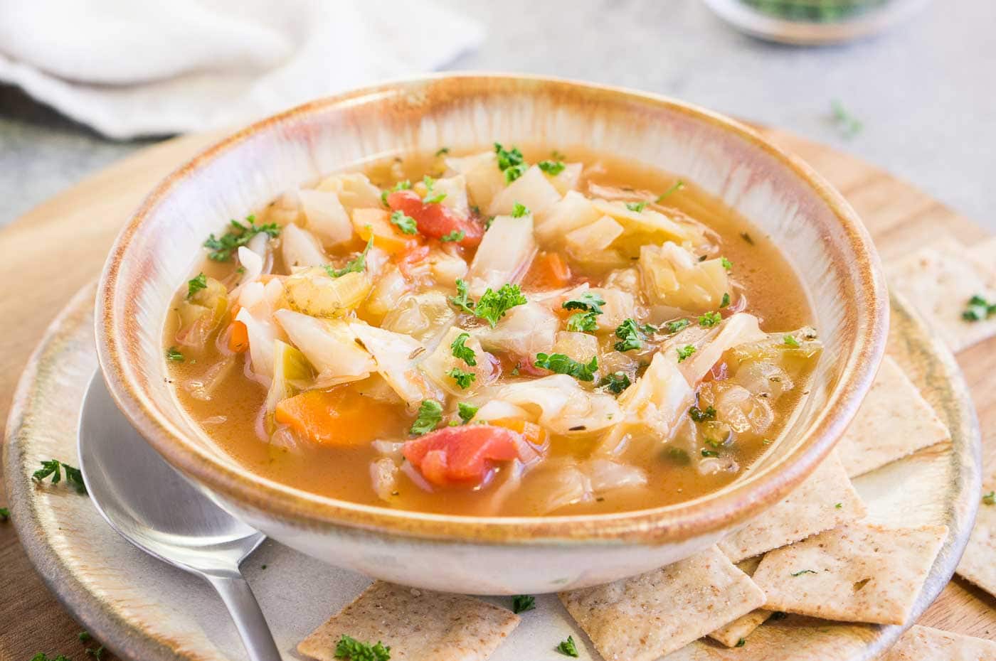 a bowl of cabbage soup with crackers