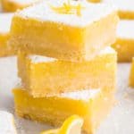 stacked lemon bars and lemon slices on a board