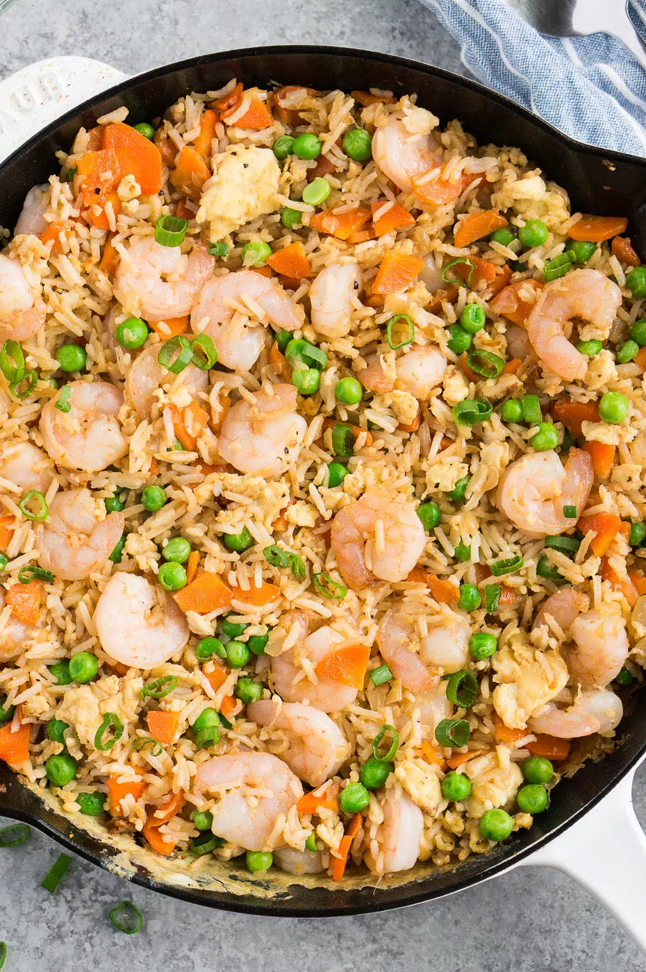 Close-up view of freshly cooked shrimp fried rice simmering in a large skillet, highlighting the textures and vibrant colors.