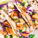 shrimp tacos recipe with cilantro lime sauce on a board