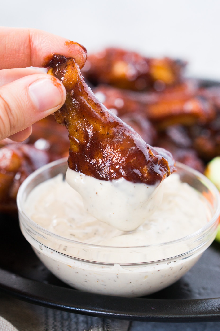 dipping chicken wing in ranch sauce