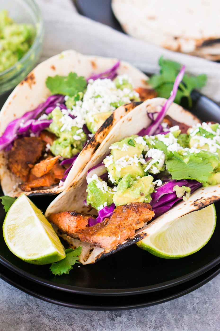 fish tacos with salmon, avocados, cabbage on a plate