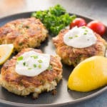 crab patties with tartar sauce on a plate