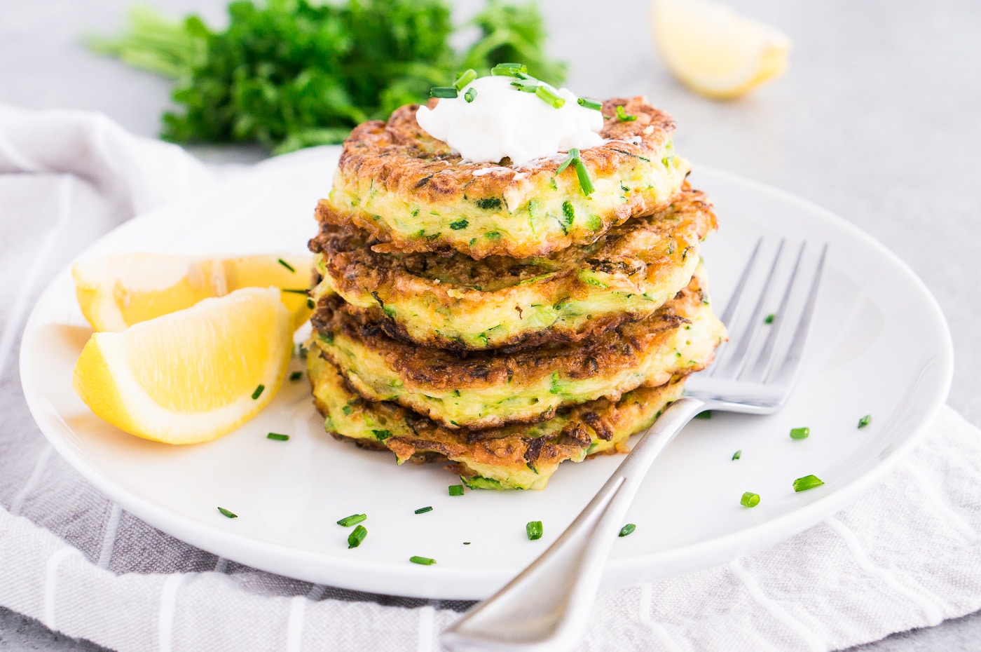 zucchini patties with sour cream on a plate