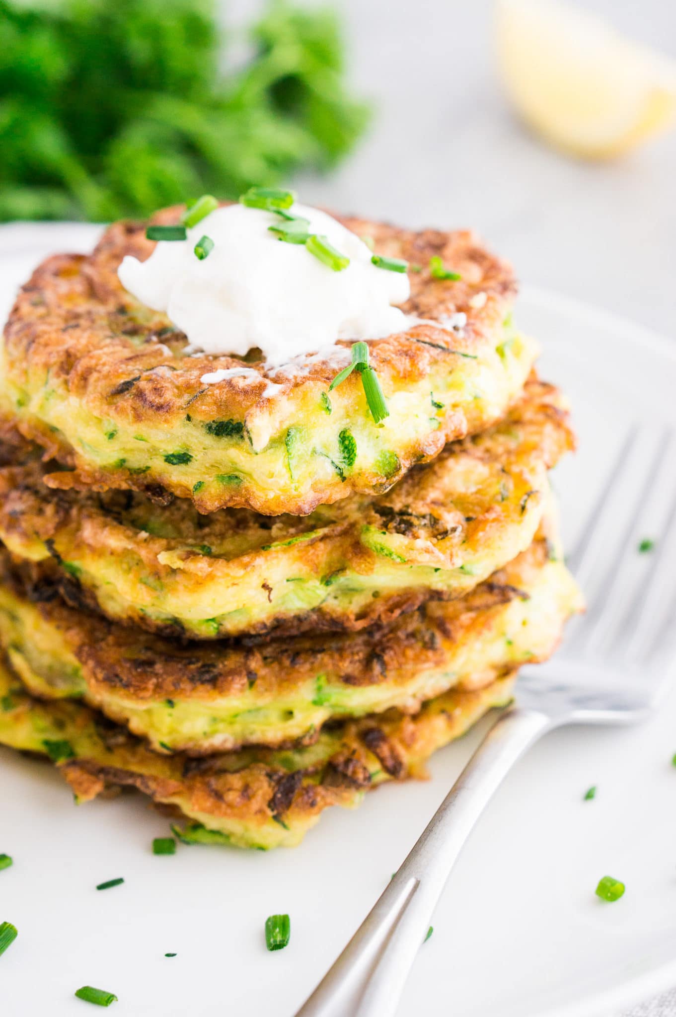 low carb zucchini pancakes on a white plate with a fork