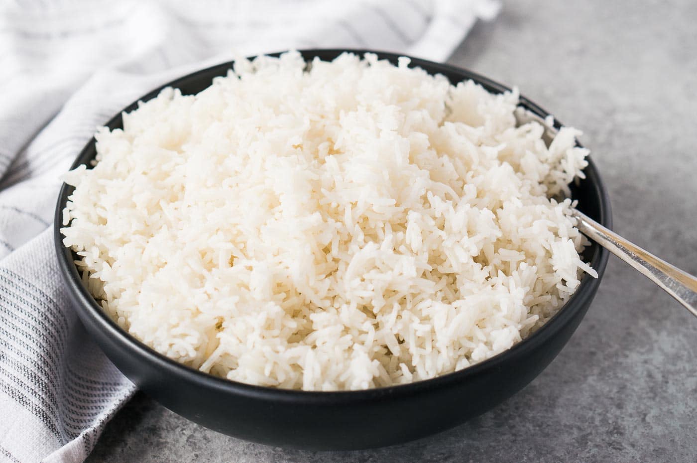 close of white rice in a black bowl