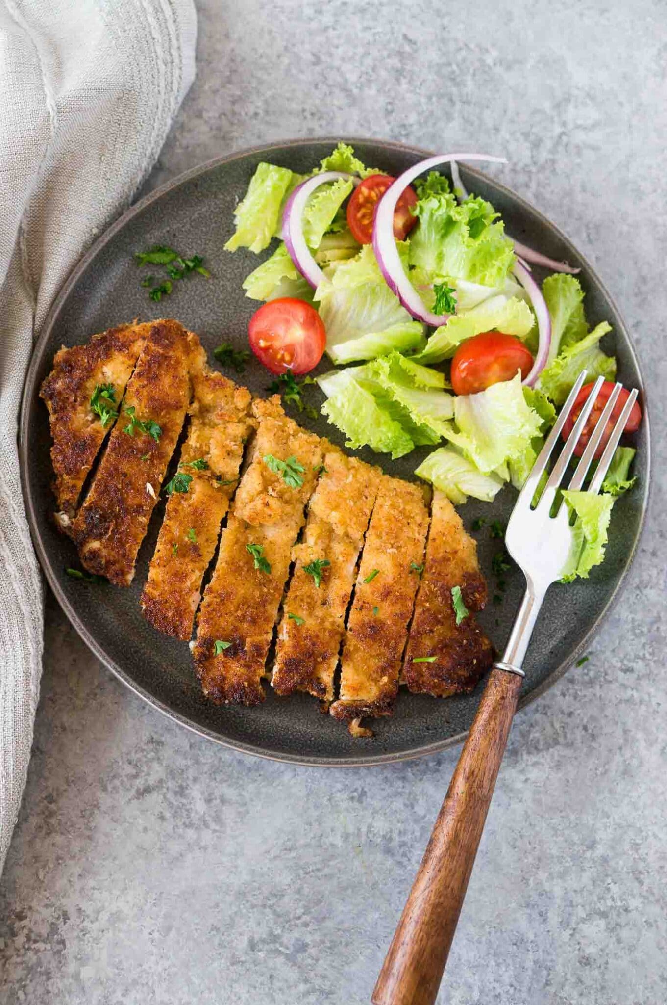 breaded chicken cutlet and a light salad on a plate