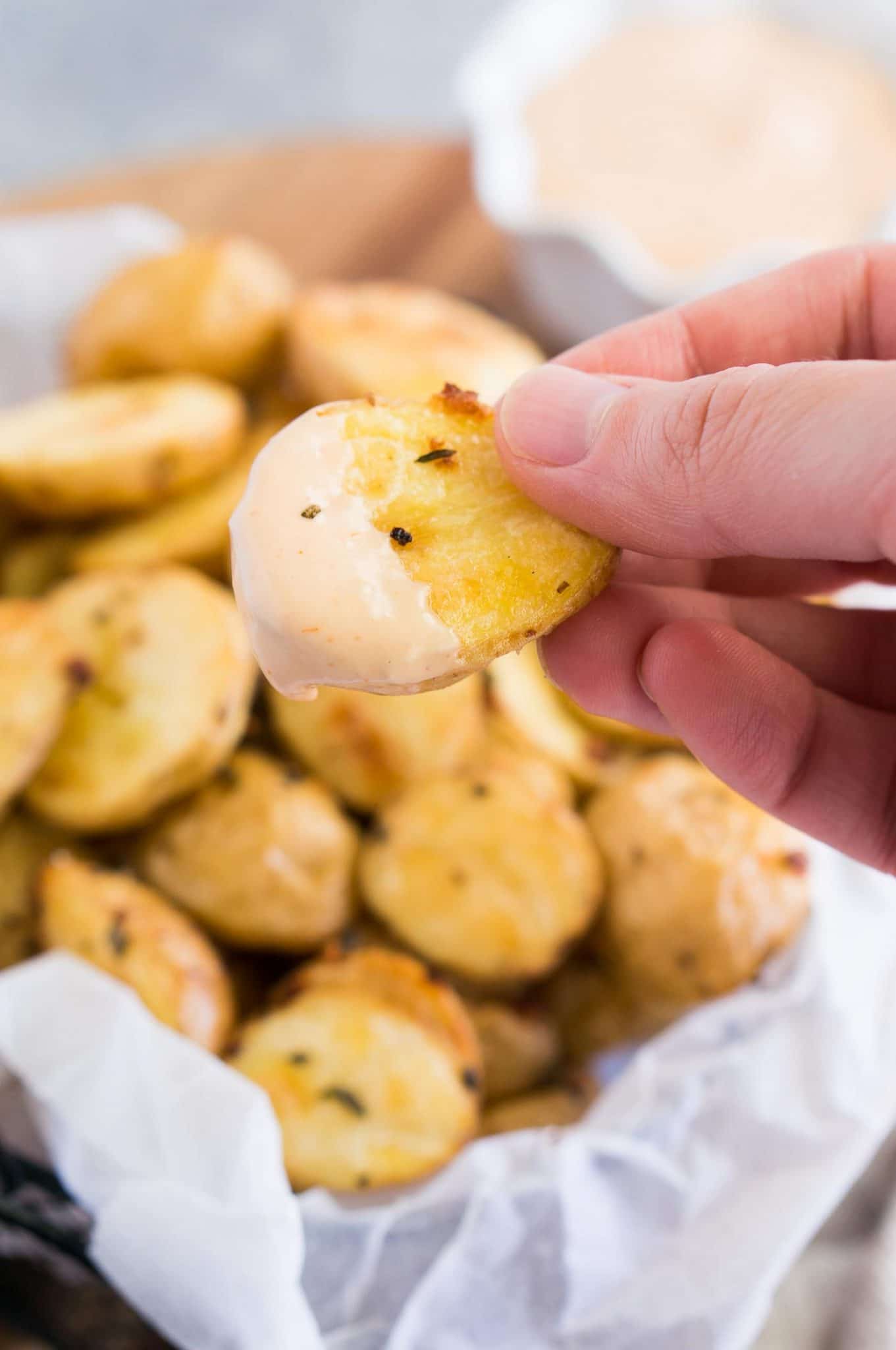 dipping roasted potatoes in a sauce