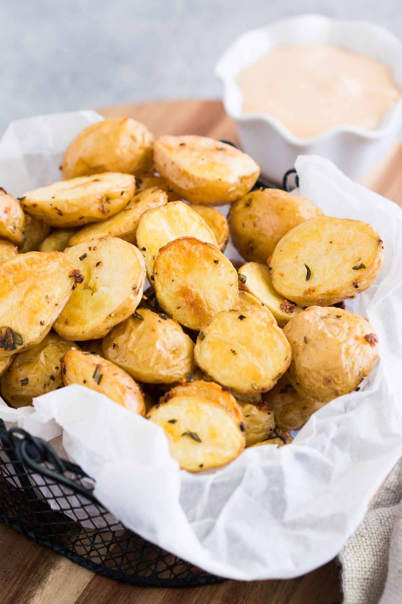 roasted baby potatoes in a basket and with a dipping sauce