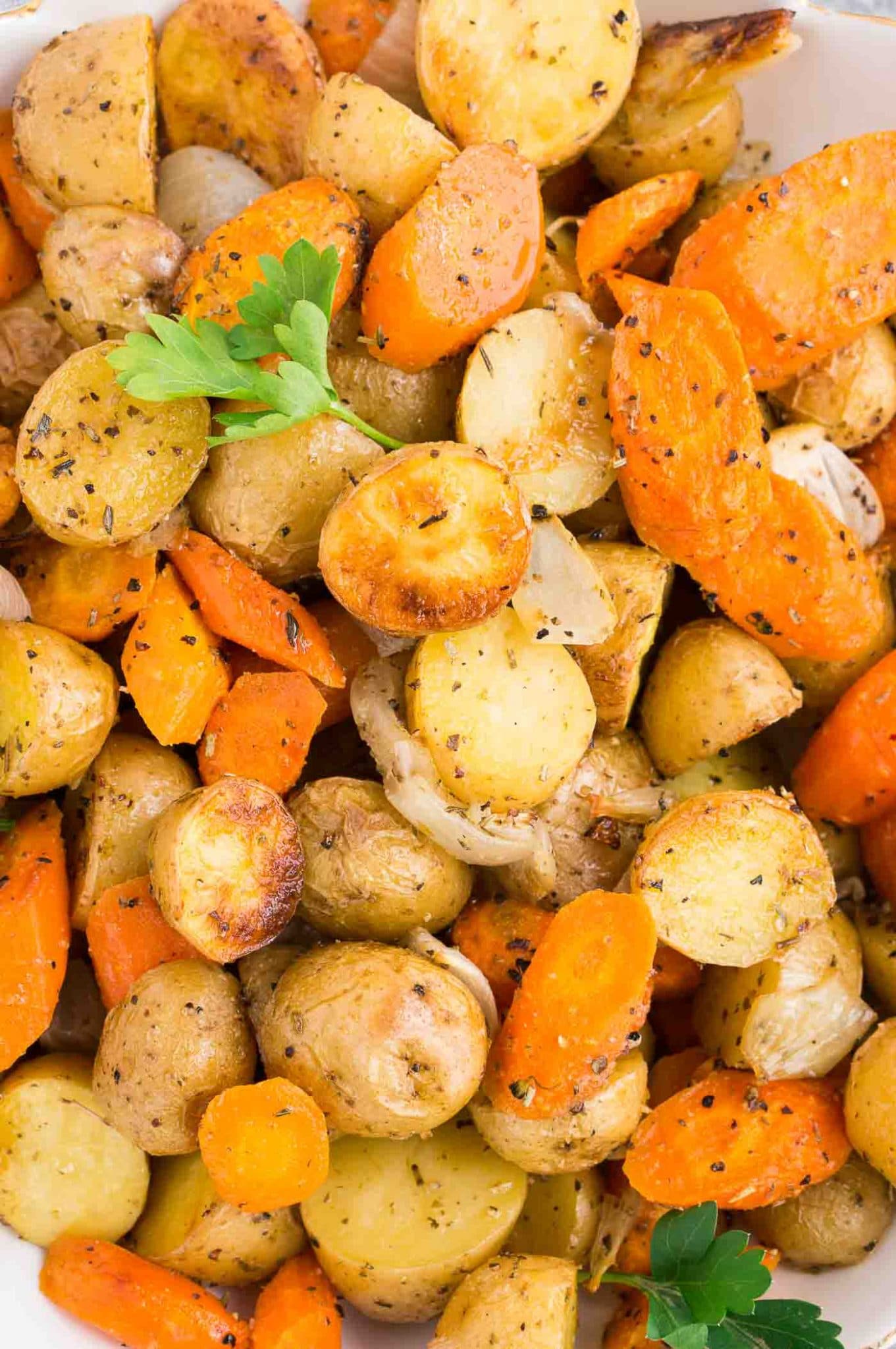 close up image of baked potatoes and carrots and onions