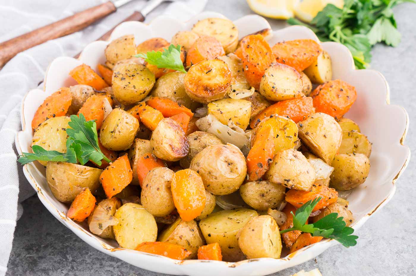 close up image of baked potatoes and carrots in a serving bowl