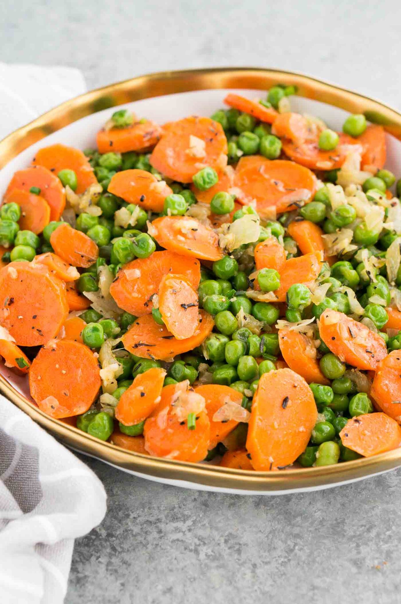 vegetarian side dish with carrots onions and peas in a bowl