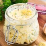 close up image of garlic and herb butter in a jar