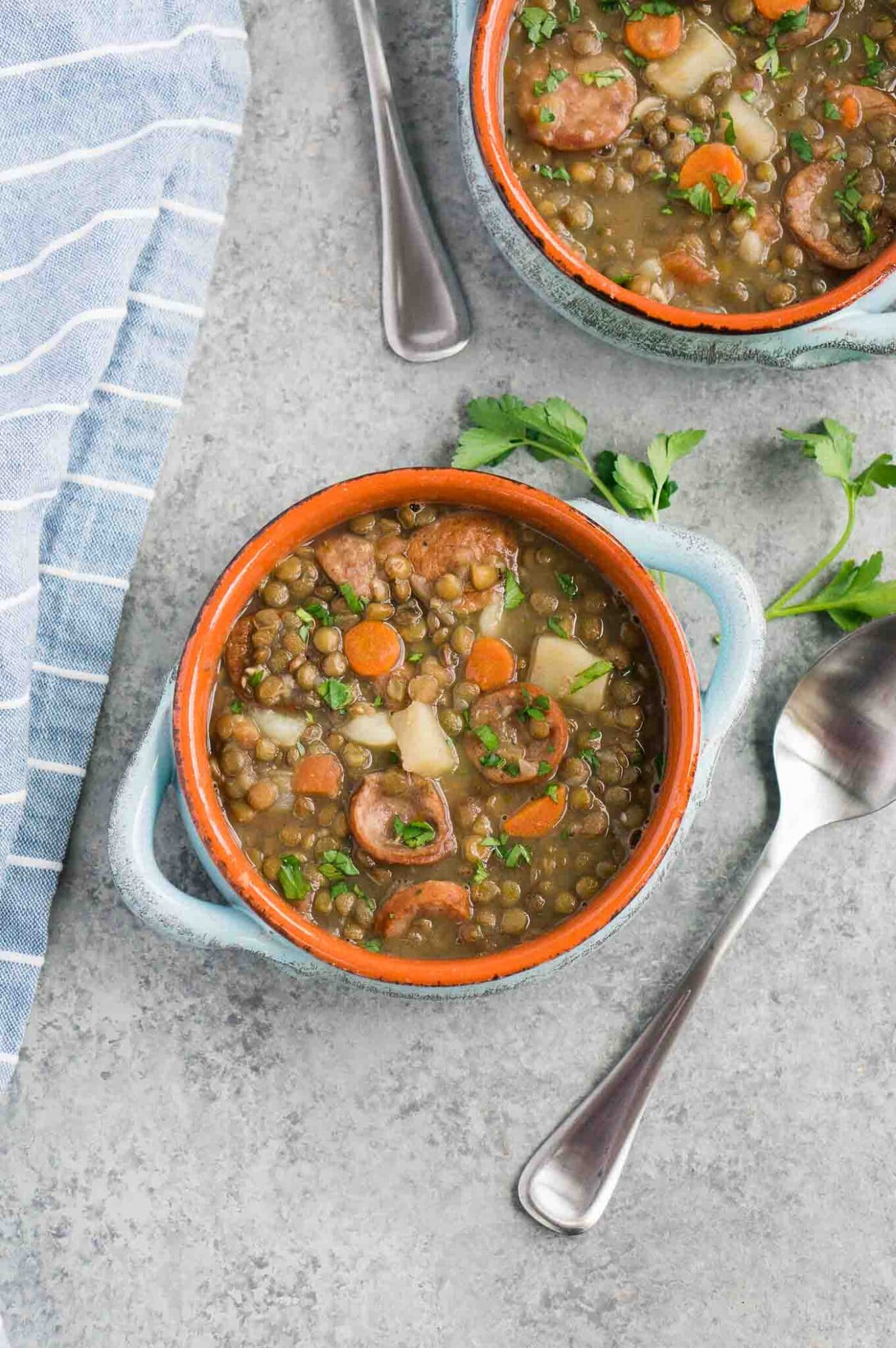 two bowls of vegetable soup with lentils and sausage