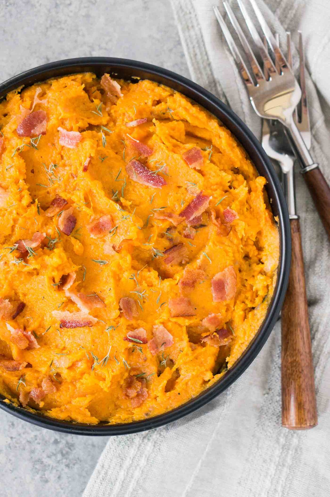 mashed sweet potatoes with bacon in a bowl