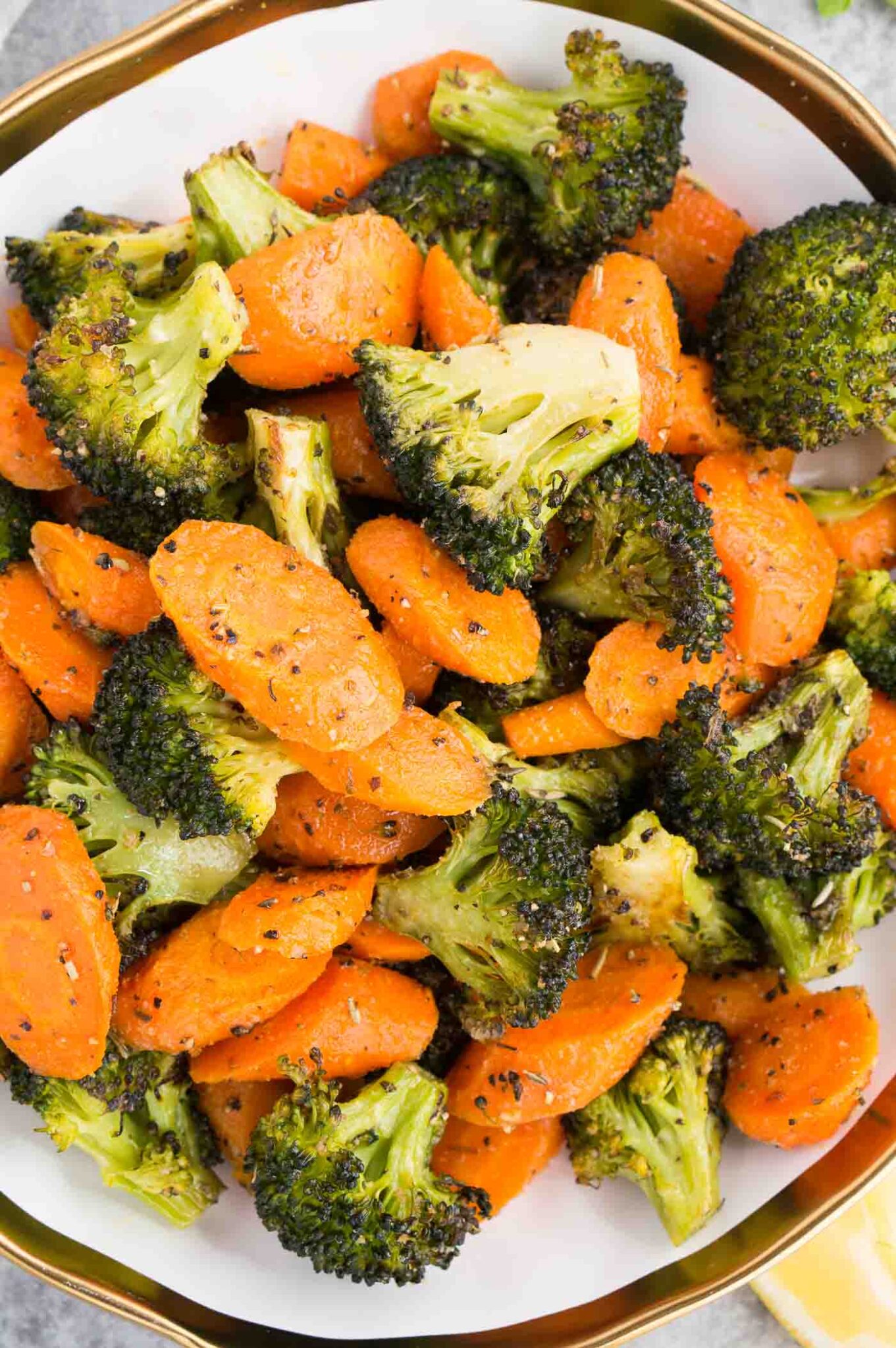 close up image of roasted carrots and broccoli in a bowl