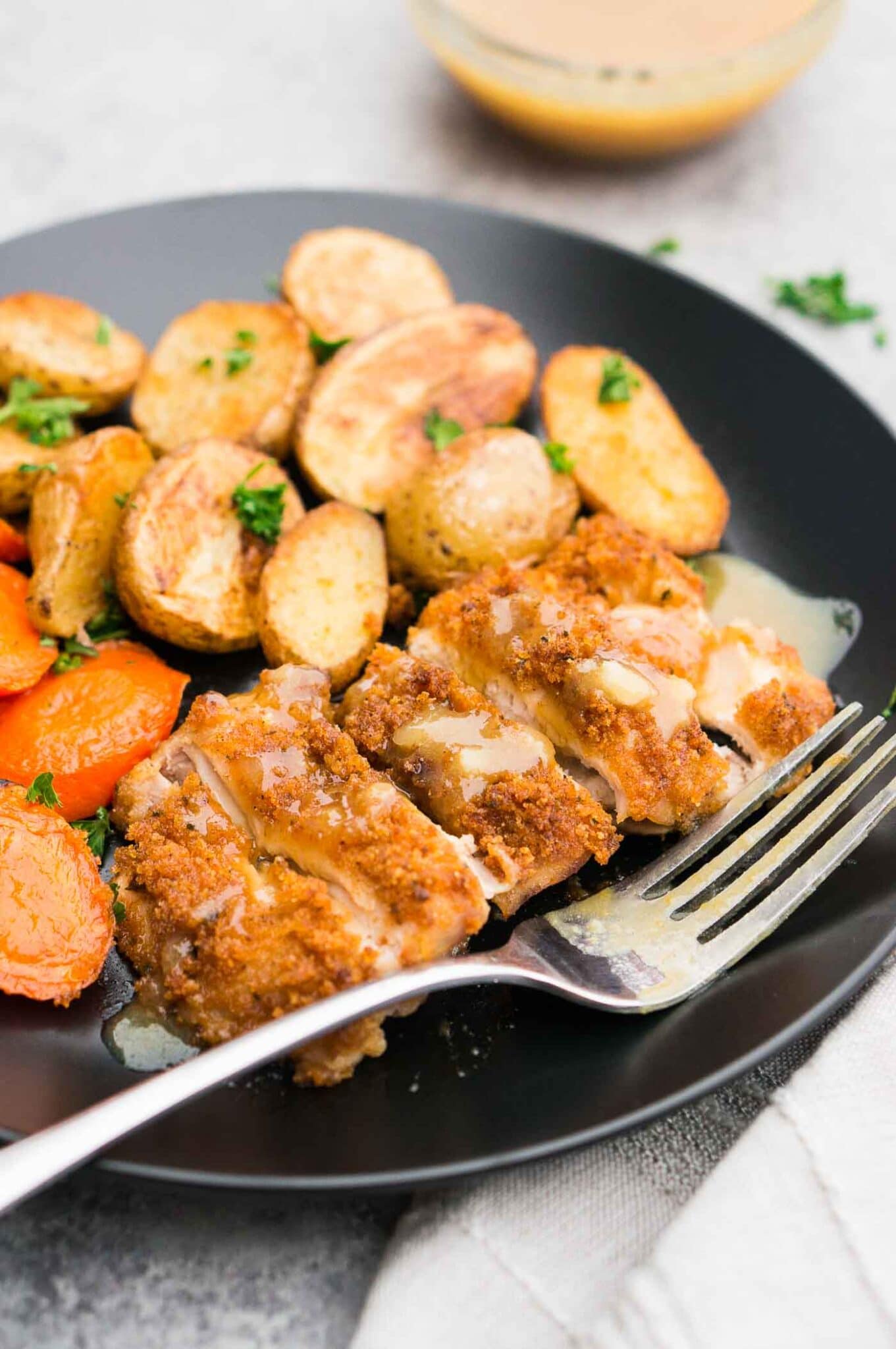sheet pan panko chicken with carrots and potatoes on a plate