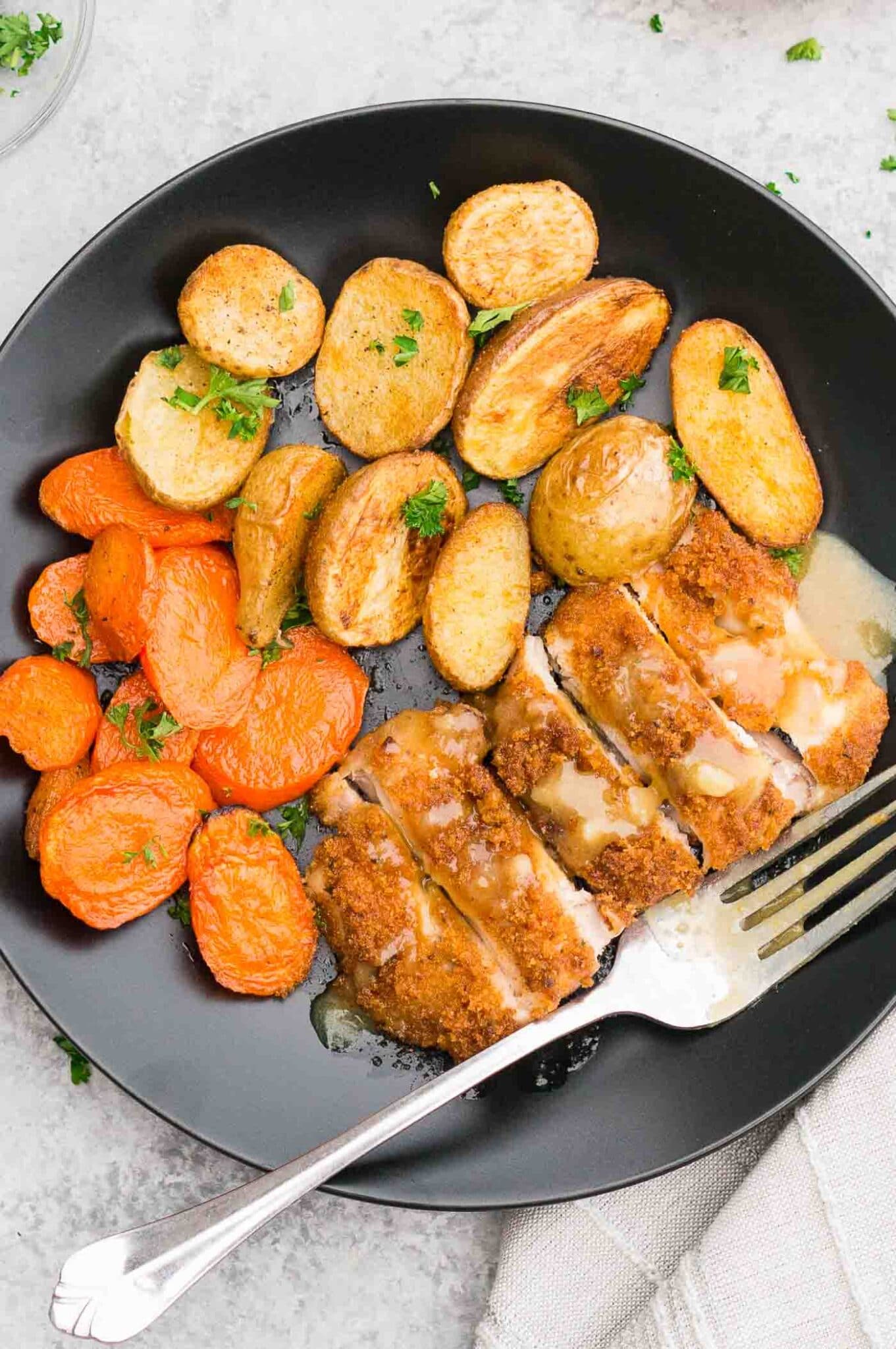close up image of chicken dinner with potatoes and carrots on a plate