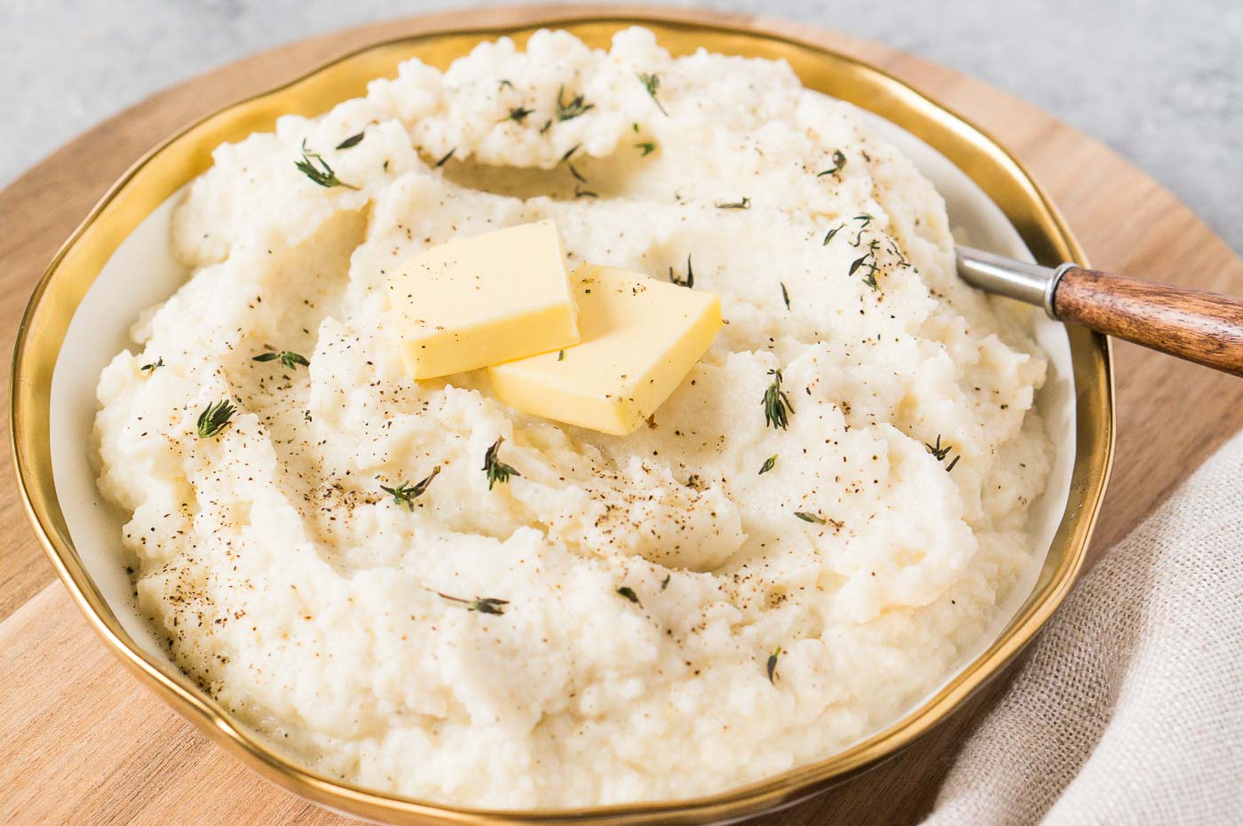 close up image of mashed cauliflower with garlic in a bowl