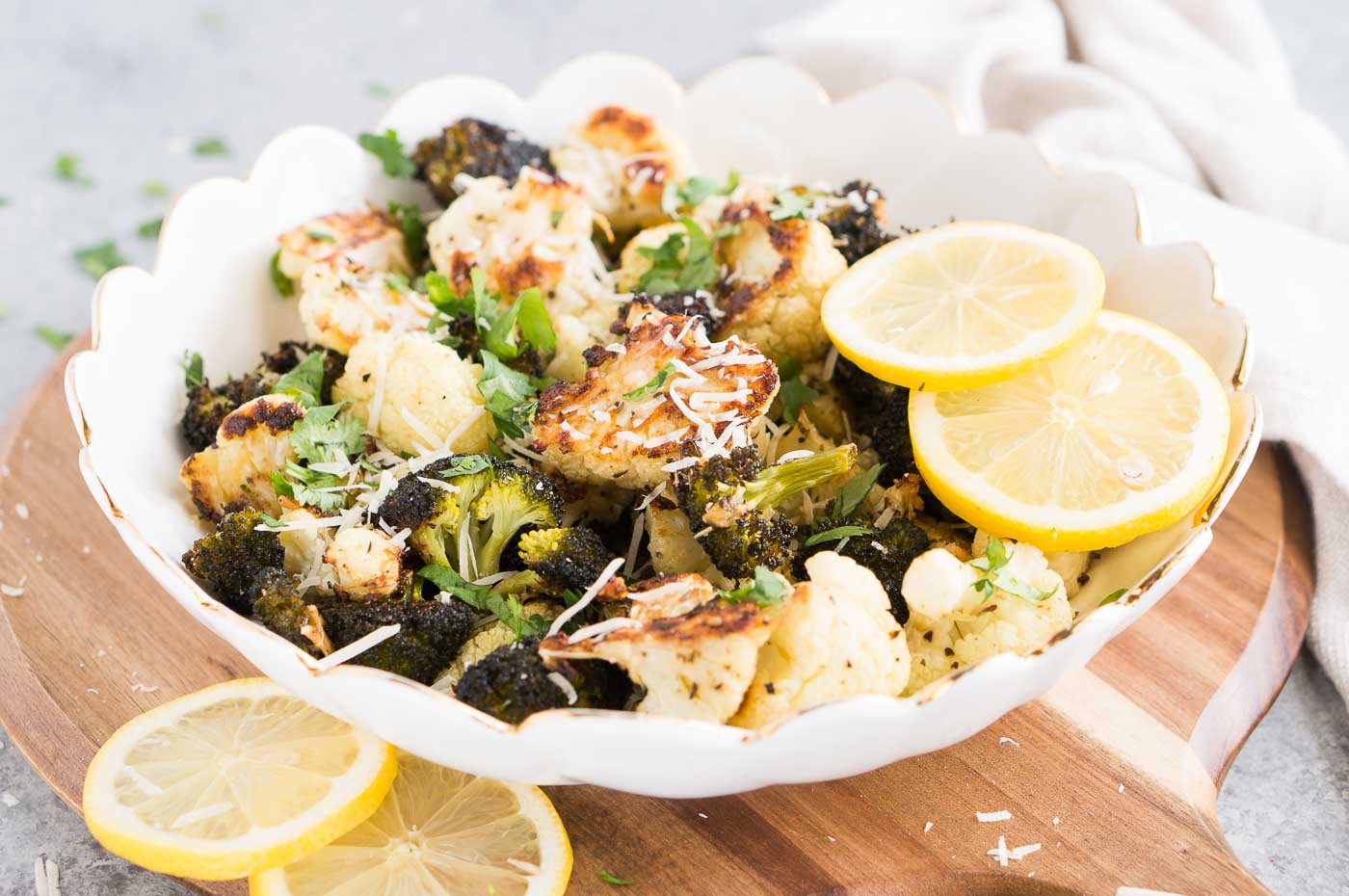 oven roasted broccoli and cauliflower served in a bowl with lemon slices