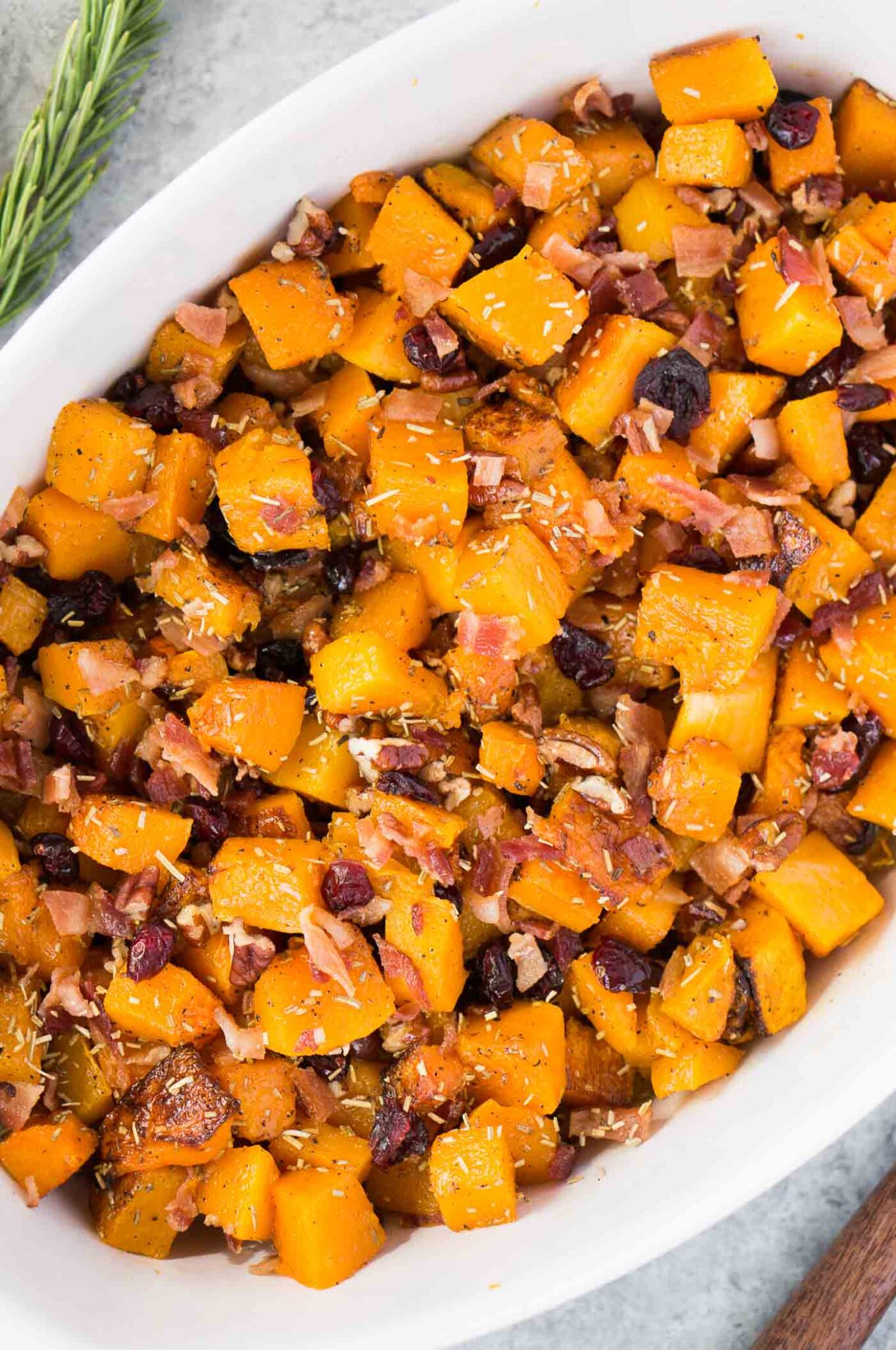 cubed and roasted butternut squash with bacon and pecans in a casserole dish