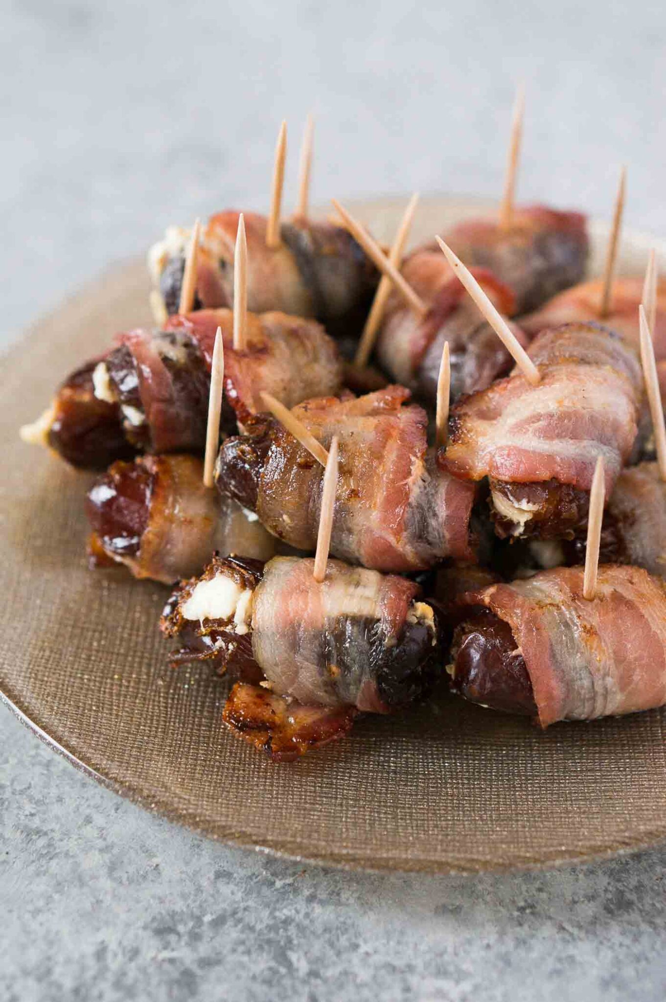 bacon wrapped dates stuffed with goat cheese on a festive plate