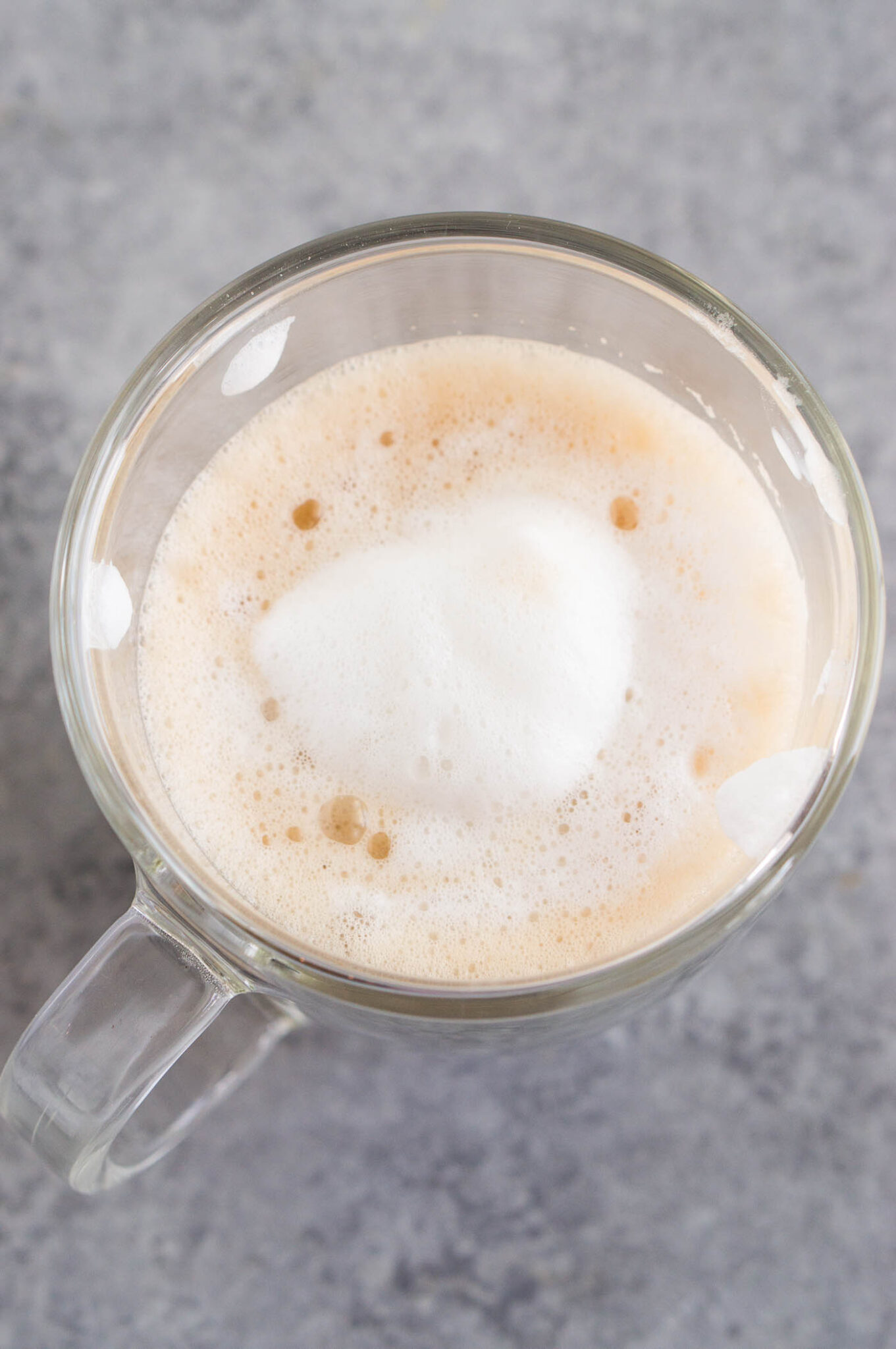 image from above of frothed milk over coffee