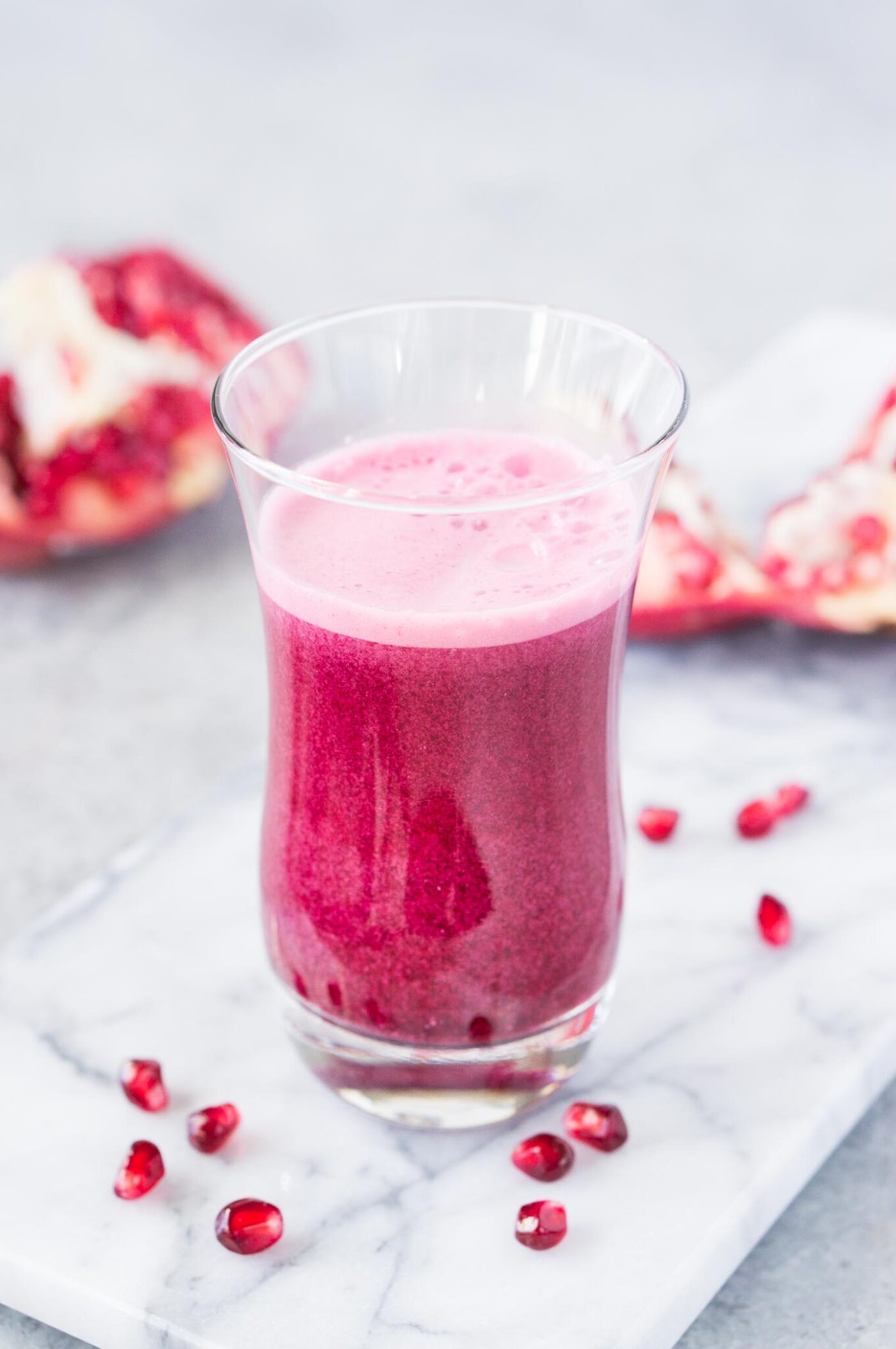 close up image of juiced pomegranate arils in a glass