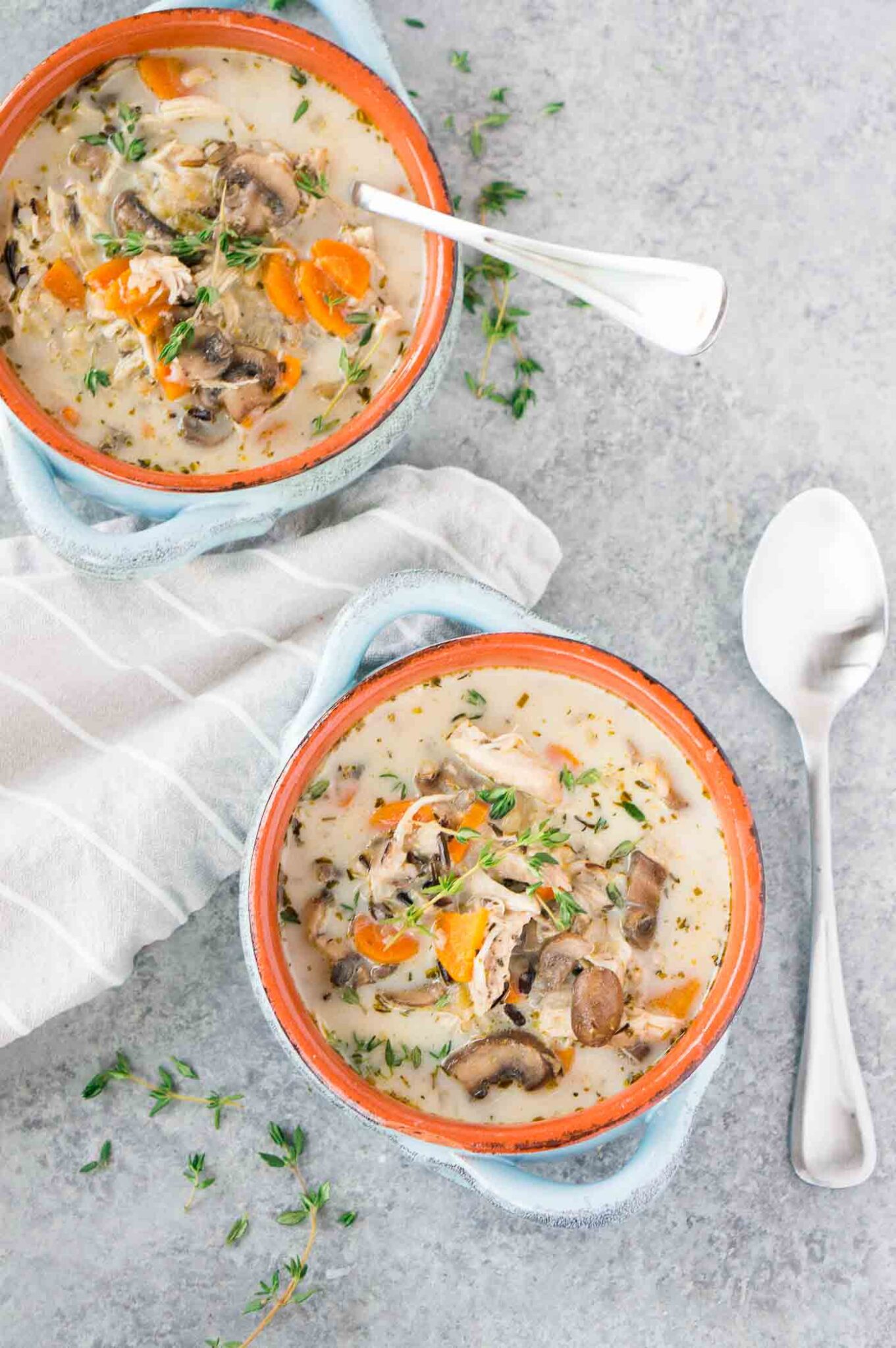 creamy chicken rice soup in two clay bowls