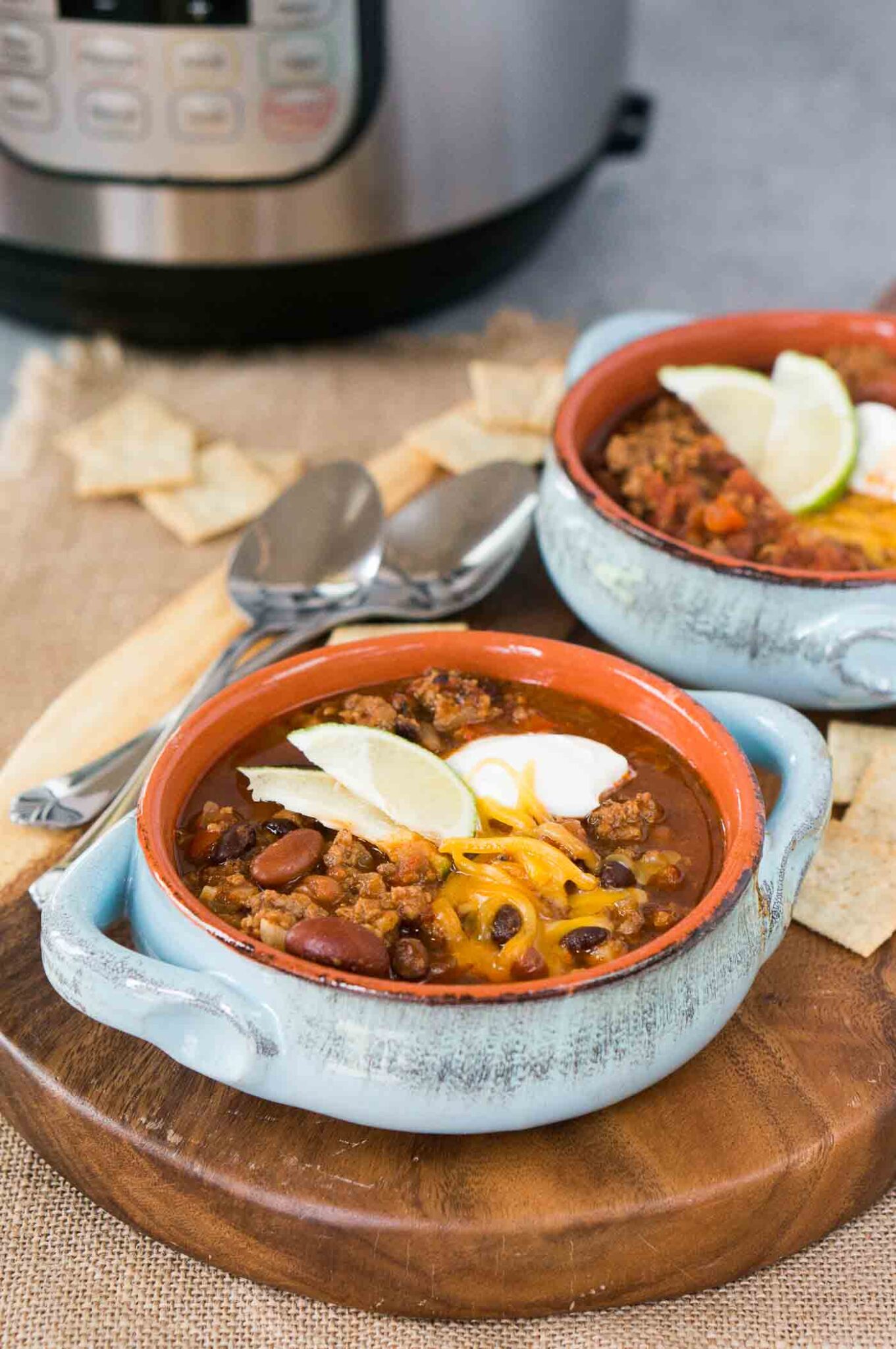 chili in bowls with pressure cooker in background